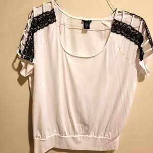 White shirt with black lace openings on the sleeves.